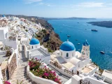 Blue-domed white buildings above the Mediterranean Sea in Santorini